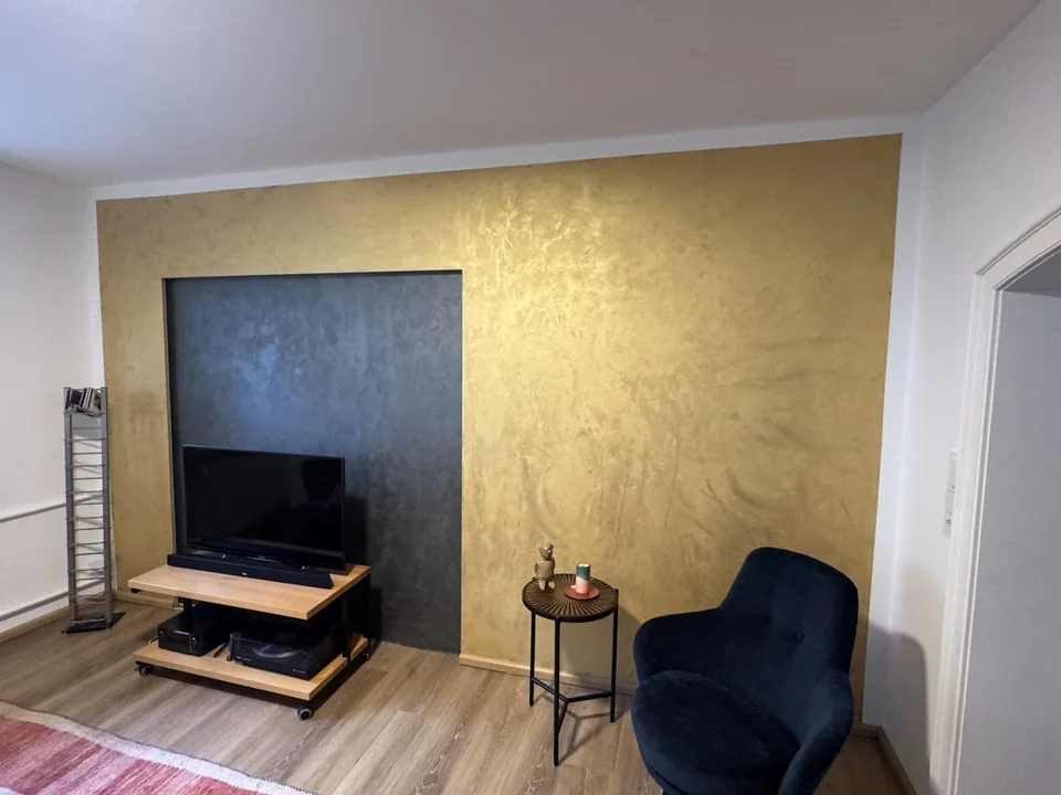 Fernseherwand mit metallischer Spachteltechnik und indirekter Beleuchtung