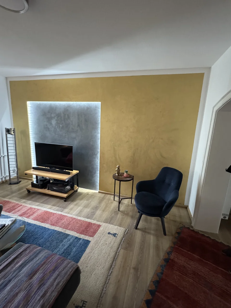 Fernseherwand mit metallischer Spachteltechnik und indirekter Beleuchtung